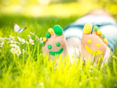Common paediatric foot conditions - child lying down in grass barefoot