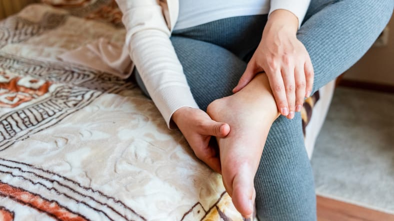 Woman assessing feet while looking after her footcare during pregnancy