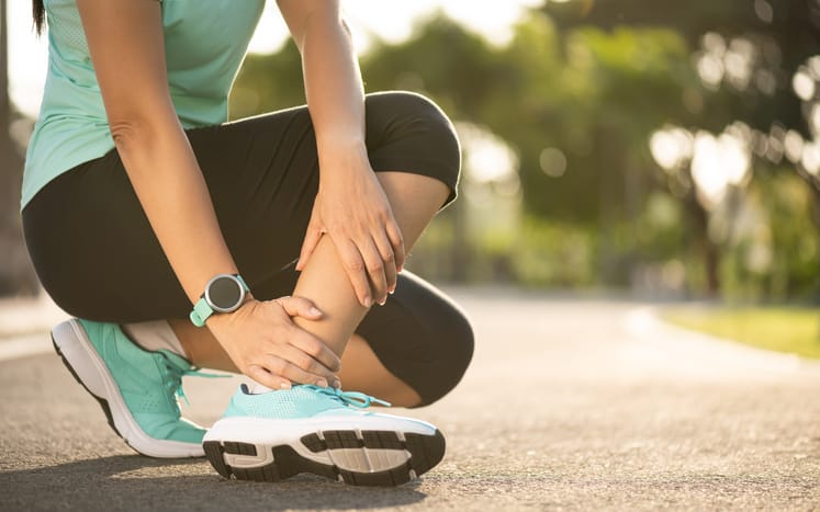 Woman suffering with foot problem during long distance running