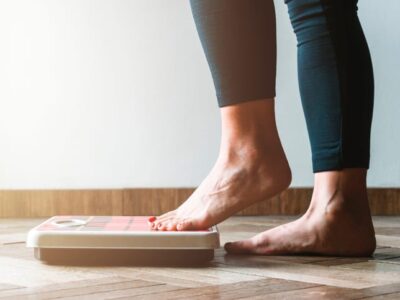 Person weighing themselves as they aim to shed some christmas pounds