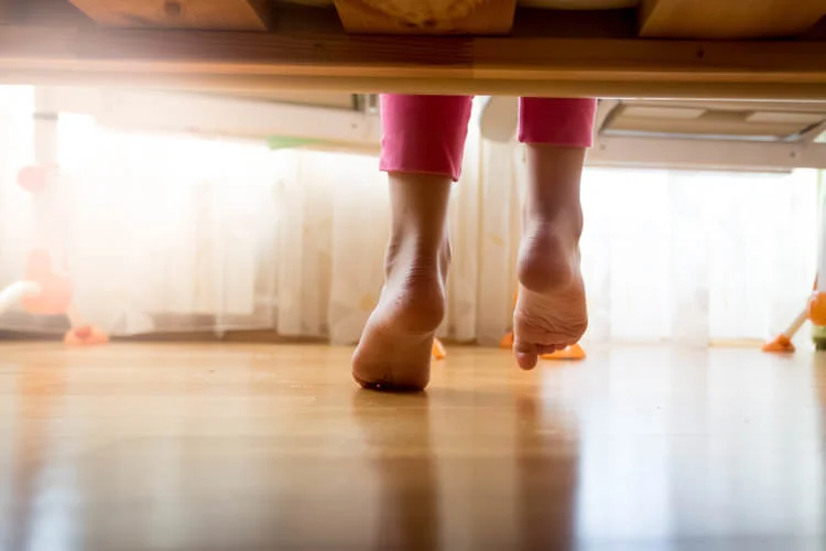 woman with flat feet getting out of bed