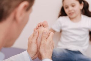 Podiatrist assessing a childs foot