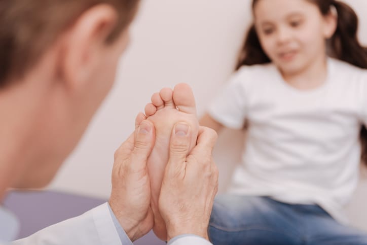 Podiatrist assessing a childs foot