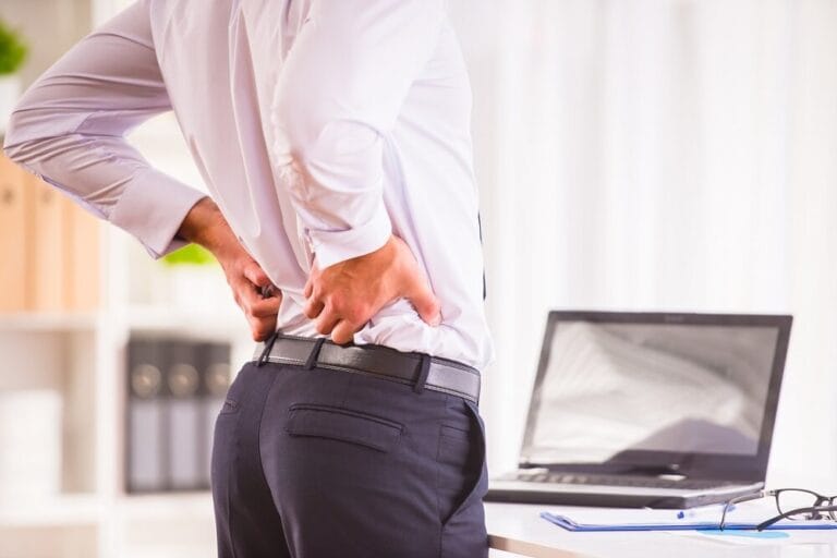 Young man stretching his lower back to relieve pain