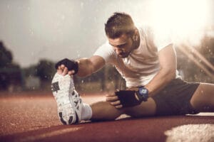 Make athlete with tight leg muscle stretching