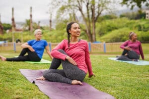 Women in a field harnessing the benefits of yoga