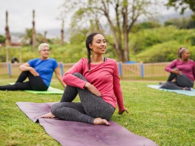 Women in a field harnessing the benefits of yoga