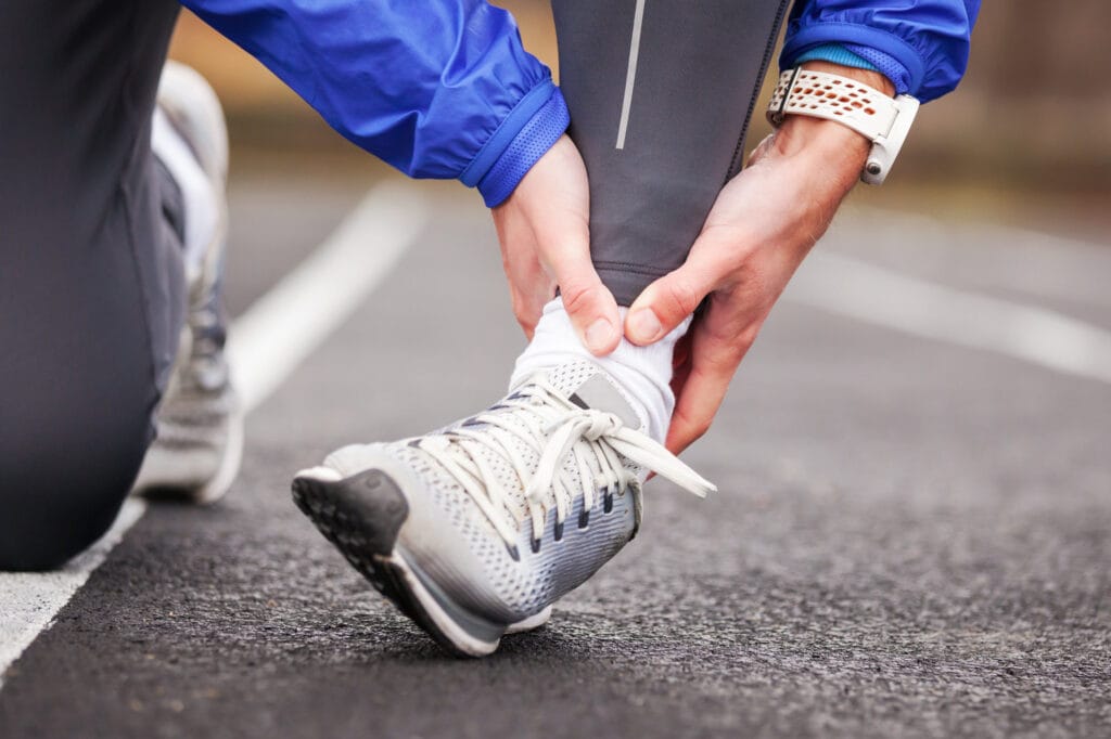 Traithlon guide - a runner checking his ankles before participating in a triathlon