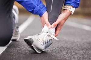 Traithlon guide - a runner checking his ankles before participating in a triathlon