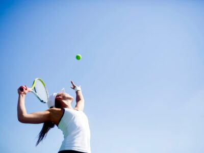 Summer injury prevention tips - a young woman playing tennis