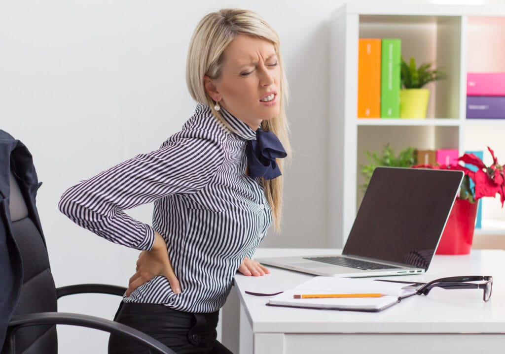 Woman with lower back pain in office chair