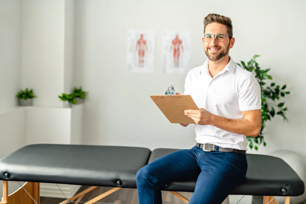Male physio sitting on a bench