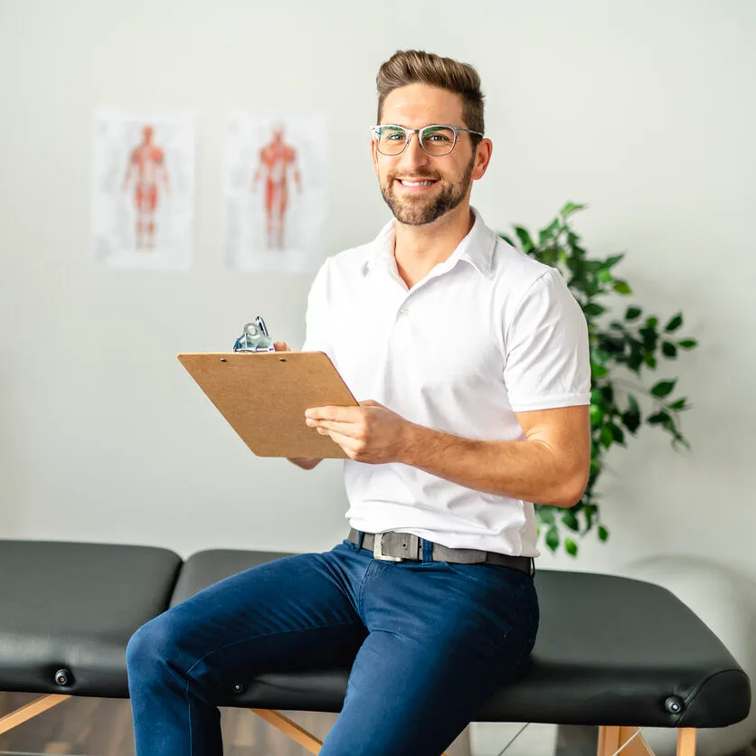 A Modern rehabilitation physiotherapy man at work Male back pain physio specialist sitting on a bench