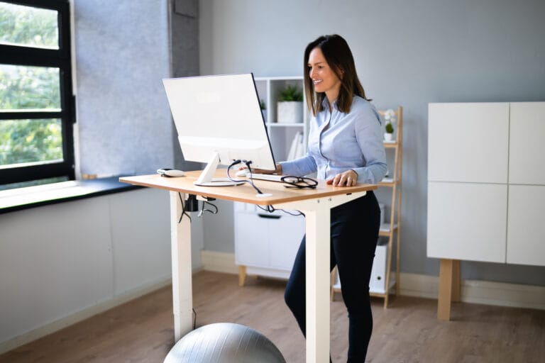 Workplace posture and ergonomics - female using standing desk for her posture