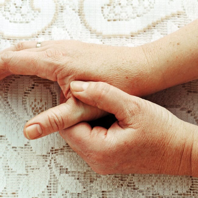Woman holding her painful thumb
