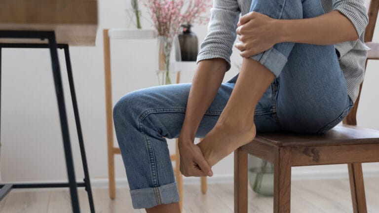 Young woman holding a stiff big toe