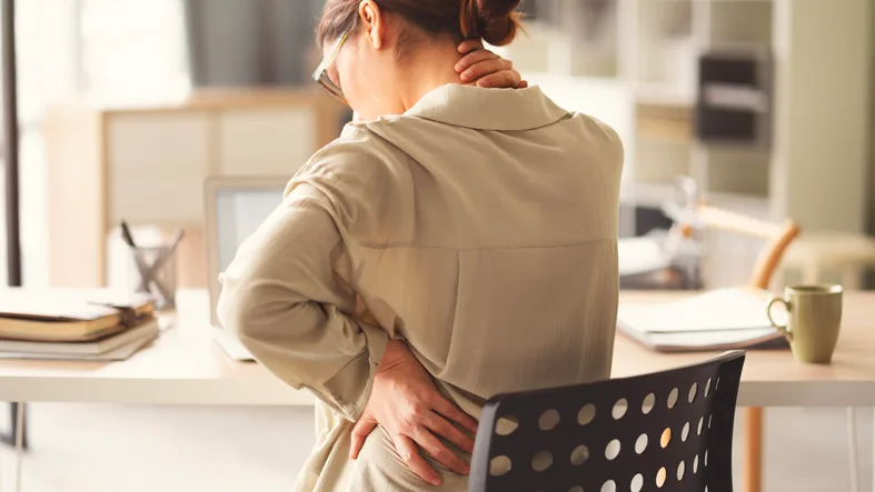 Woman with lower back pain massaging her back