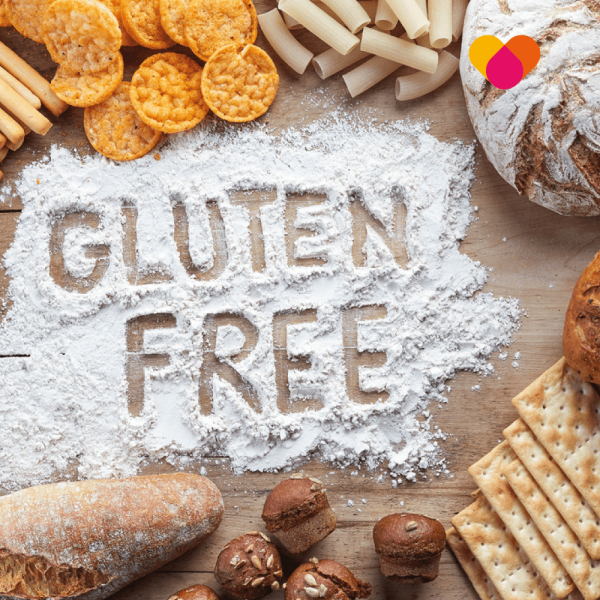 Gluten free written in powder on a table with gluten based products